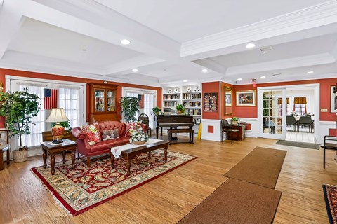 A living room with a red couch and a rug.