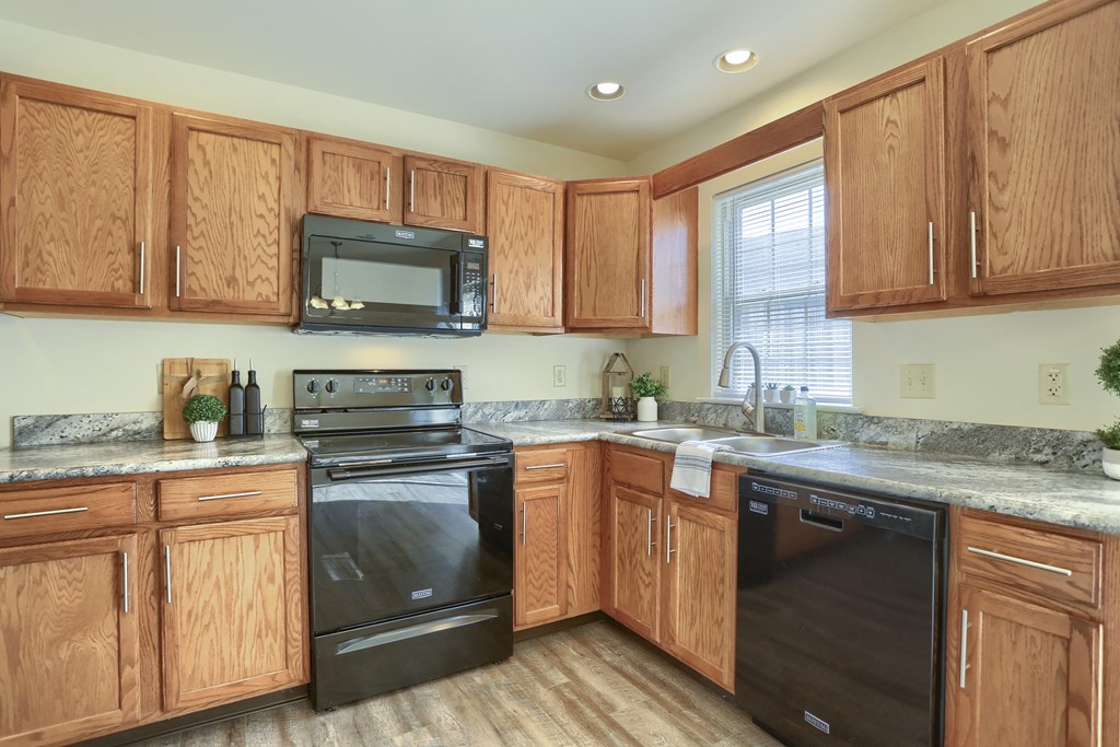 Mechanicsburg Apartments | Rockledge Townhomes |  a kitchen with wood cabinets and black appliances