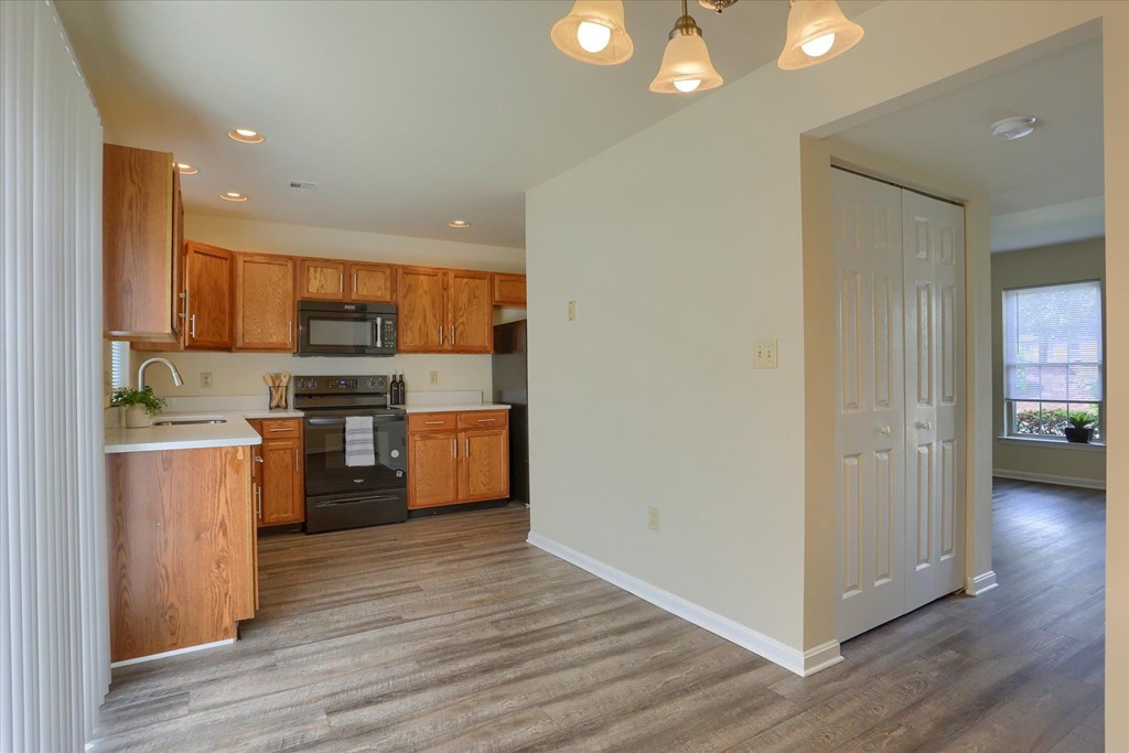 A kitchen with wooden cabinets and a microwave oven.