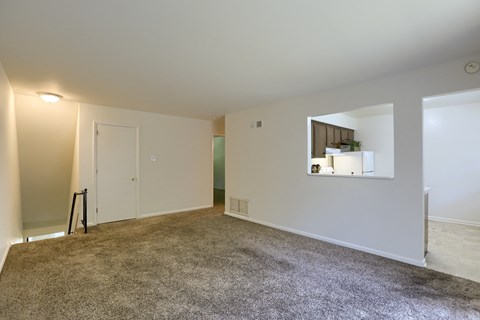 an empty living room with a mirror on the wall