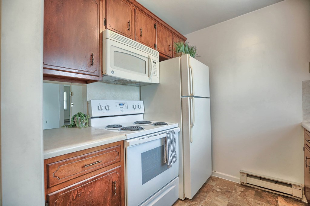 a kitchen with white appliances and wooden cabinets