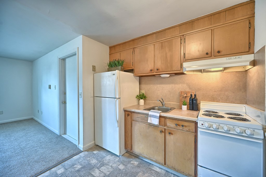 a kitchen with white appliances and wooden cabinets