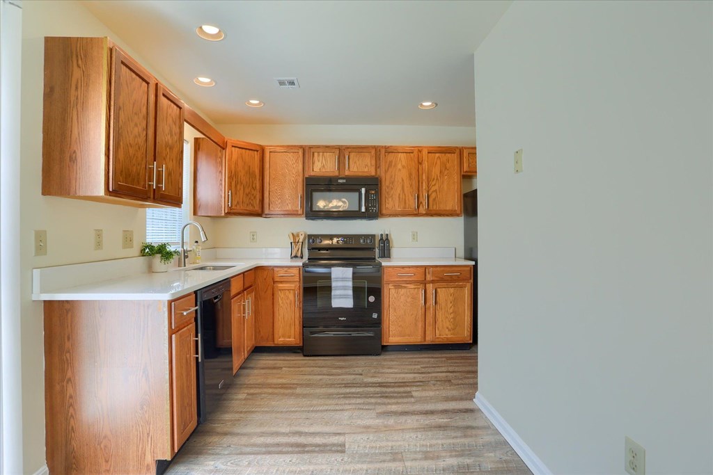 A kitchen with wooden cabinets and appliances.