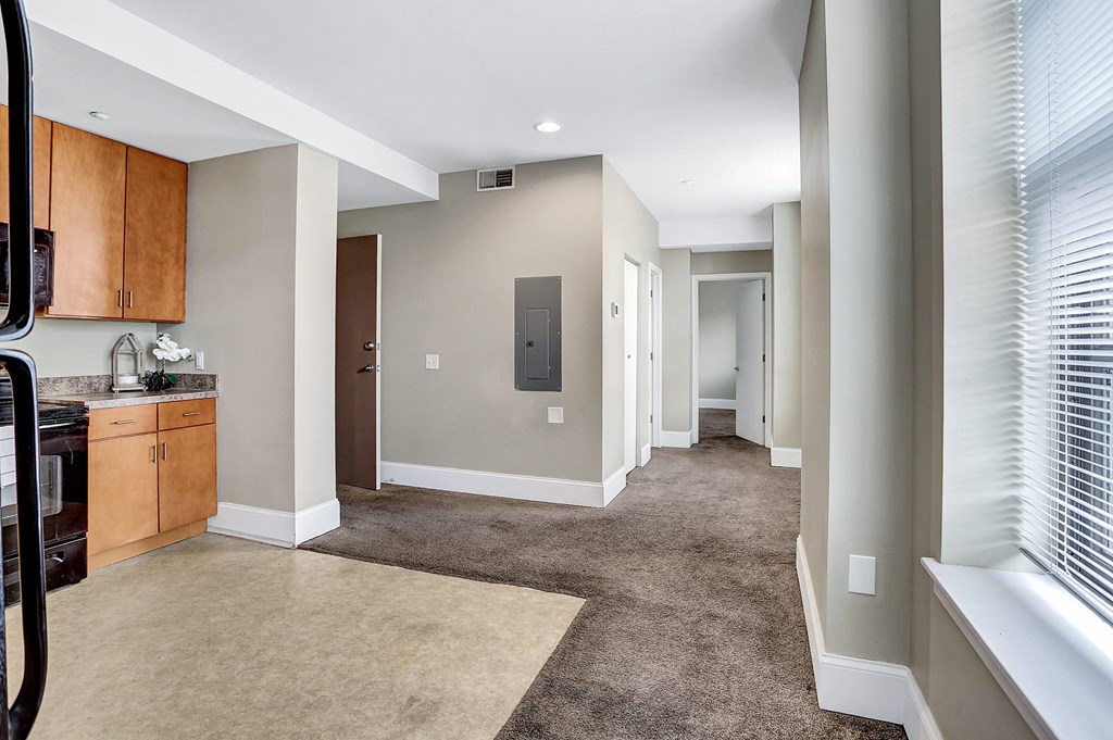 a spacious living room and kitchen with a carpeted floor