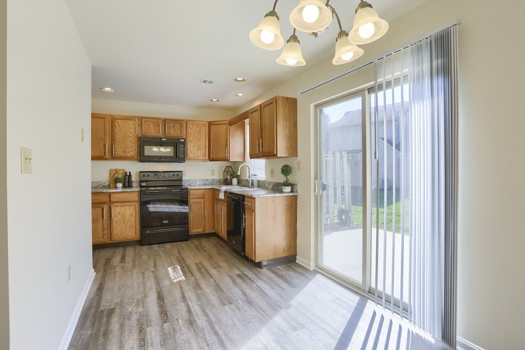 Mechanicsburg Apartments | Rockledge Townhomes |  a kitchen with wood cabinets and a sliding glass door