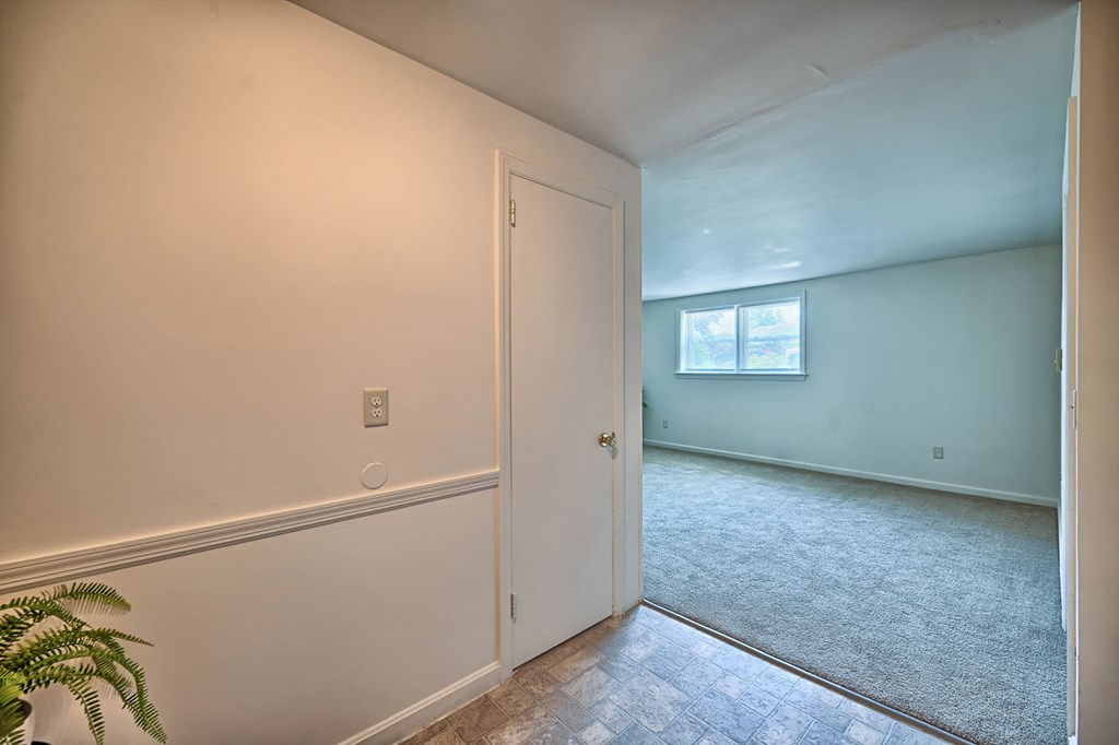 an empty room with a door and a window