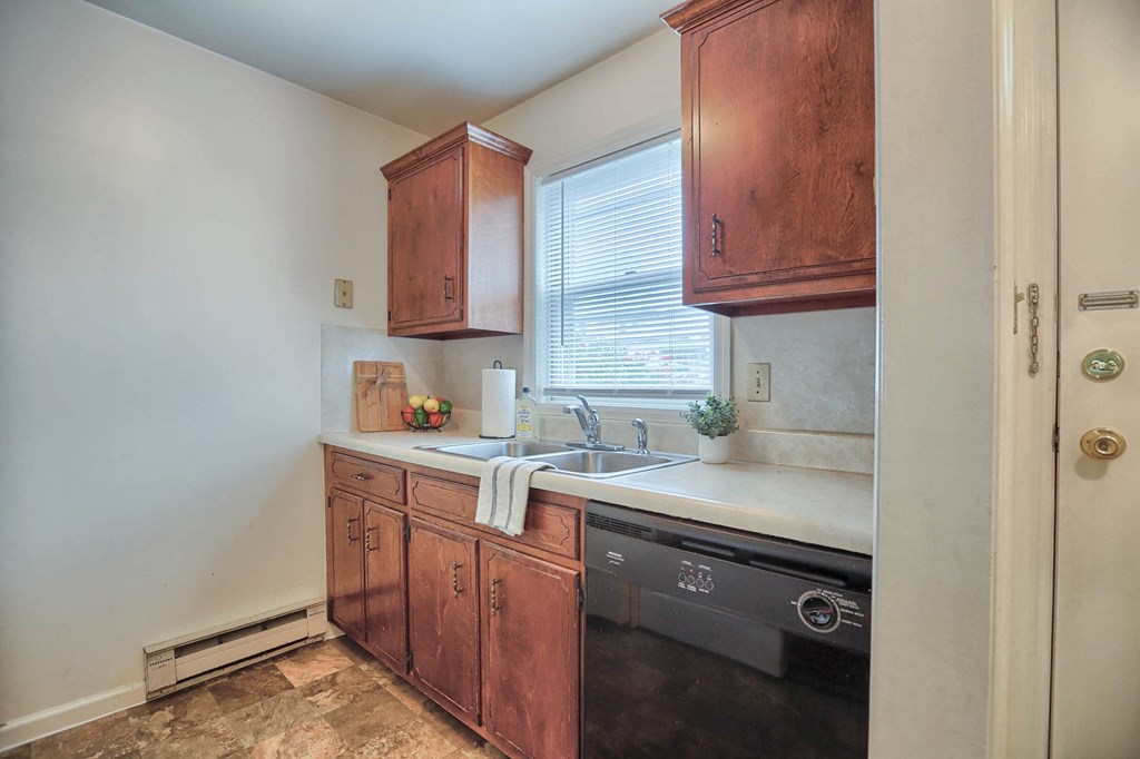 a kitchen with wooden cabinets and a sink and a window