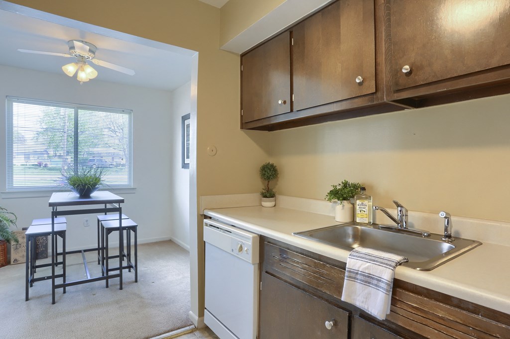 Harrisburg Apartment | Twin Lakes Apartments | a kitchen with brown cabinets and a white dishwasher