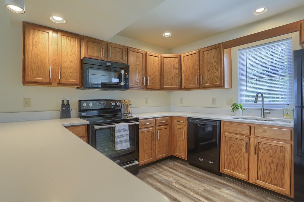 A kitchen with wooden cabinets and black appliances.