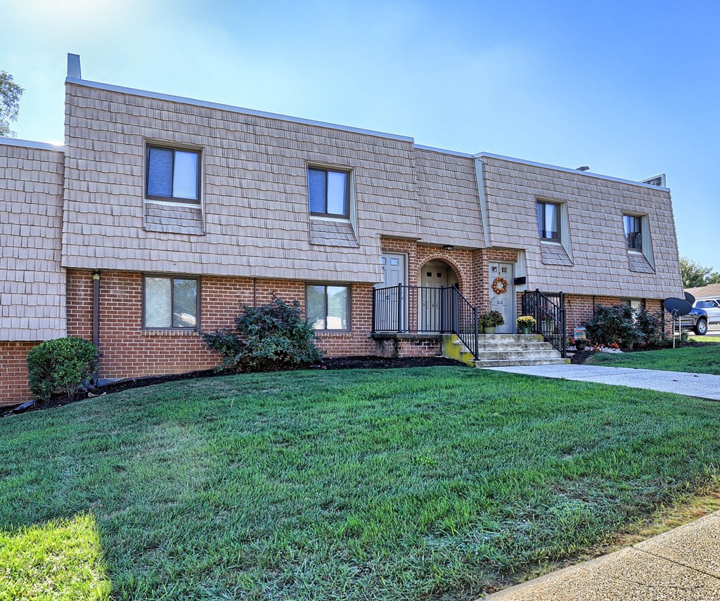 A brick house with a green lawn in front.