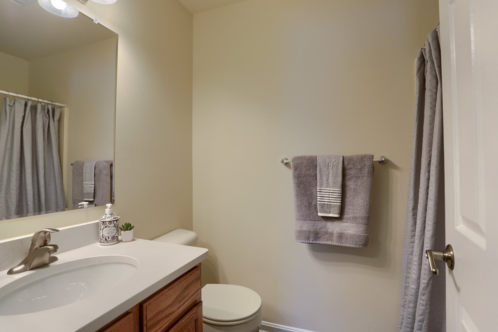 A bathroom with a toilet, sink, and towel rack.