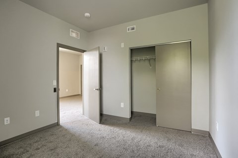 a bedroom with a carpeted floor and two closet doors