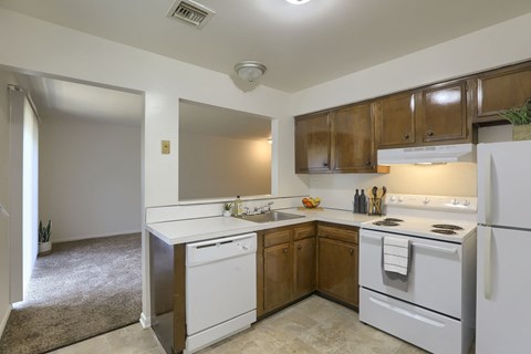 A kitchen with white appliances and wooden cabinets.