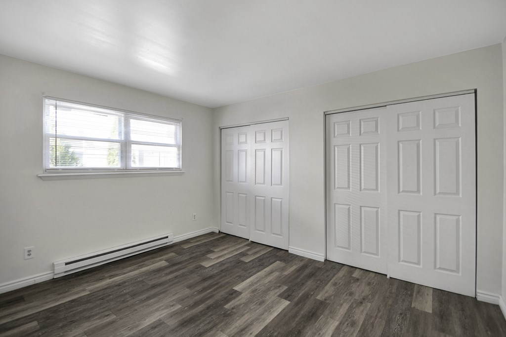 A room with a white door and a window with blinds.