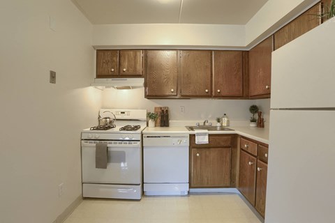a kitchen with white appliances and wooden cabinets