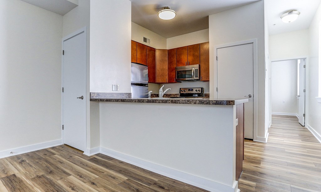 an empty kitchen with a counter top and a microwave