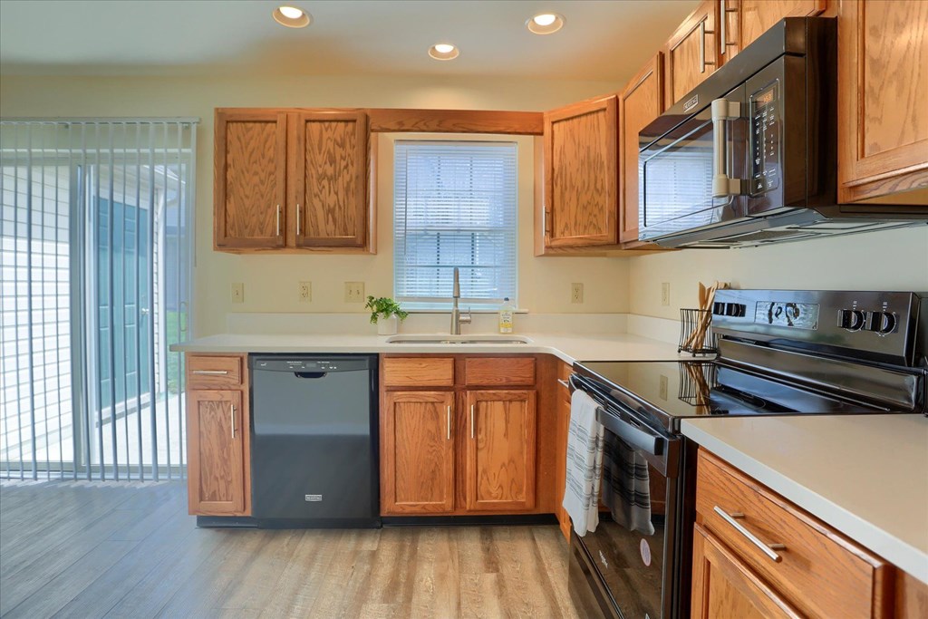 A kitchen with wooden cabinets and a black stove top oven.