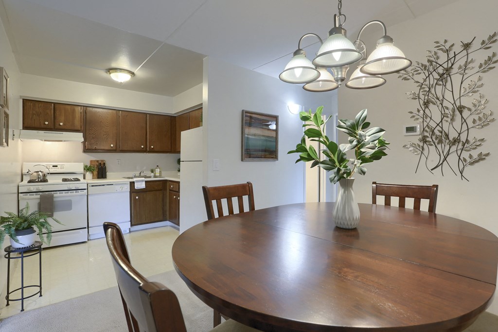 Apartments in Harrisburg | Twin Lakes Apartments | a dining area with a wooden table and chairs and a kitchen in the background