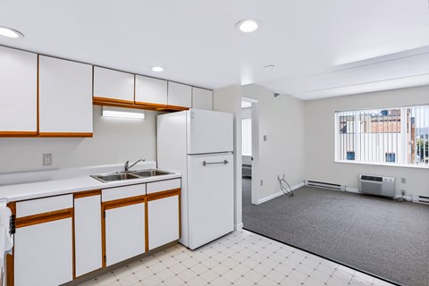 A kitchen with white cabinets and a white refrigerator.