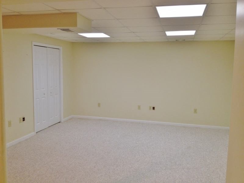 an empty room with a white floor and a white door