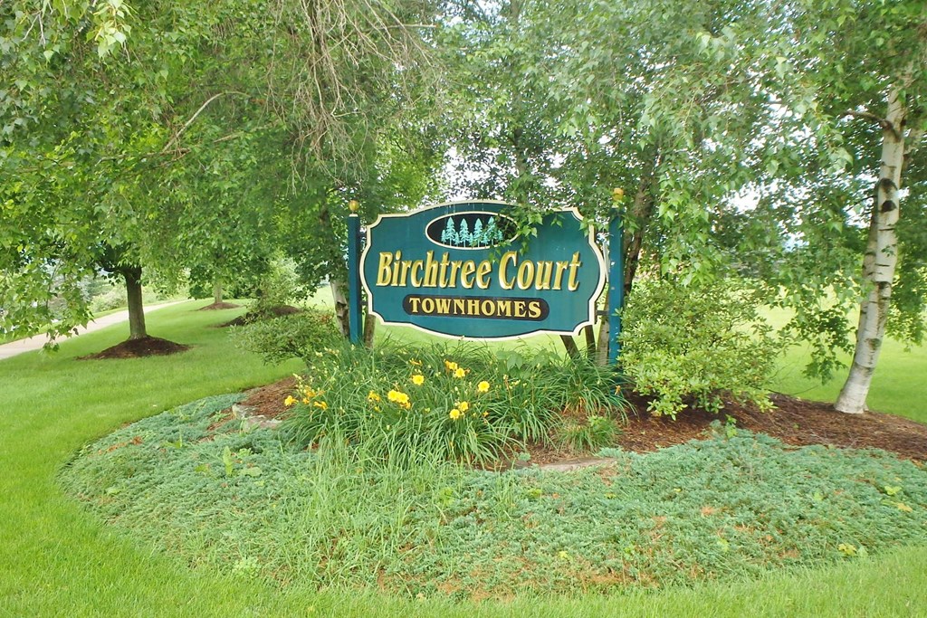 a sign court townhomes in front of trees