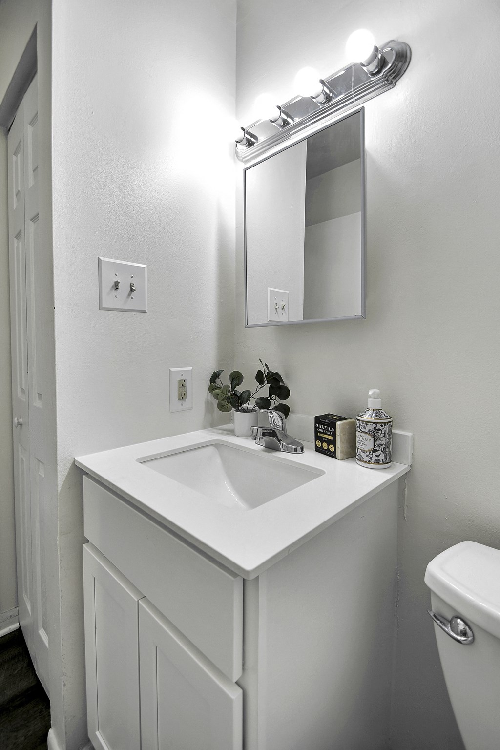 A white sink in a bathroom with a mirror above it.