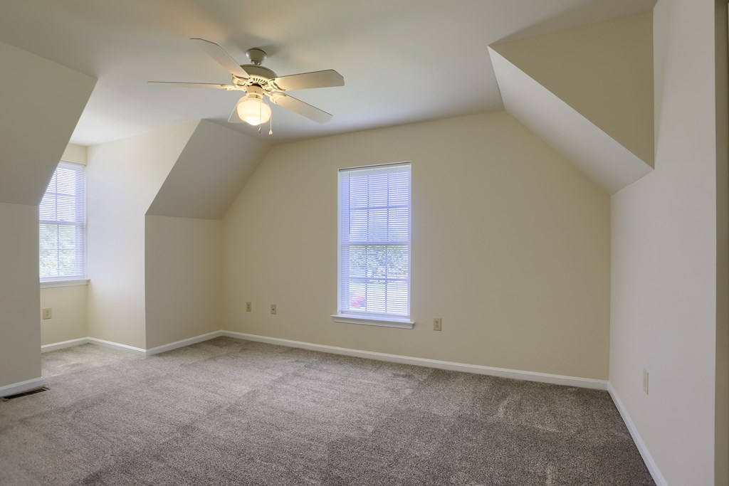A room with a ceiling fan and a window.