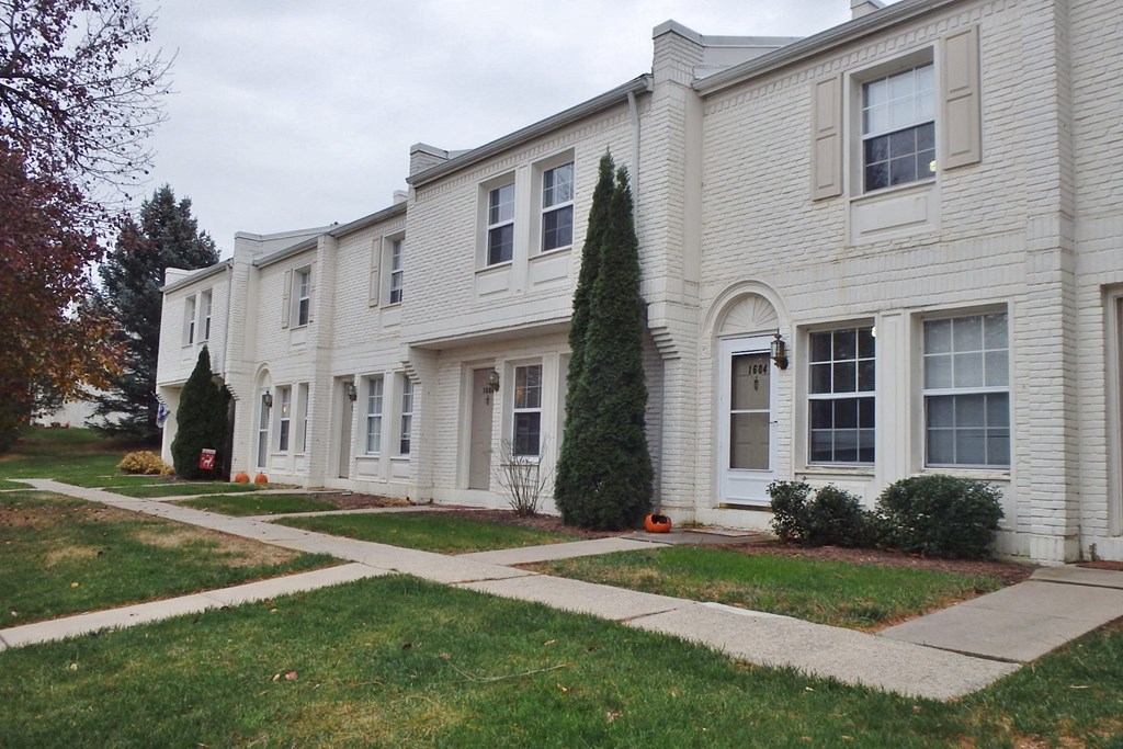 a white house with a sidewalk in front of it