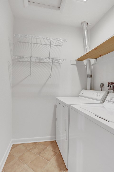a laundry room with a washer and dryer and a rack on the wall