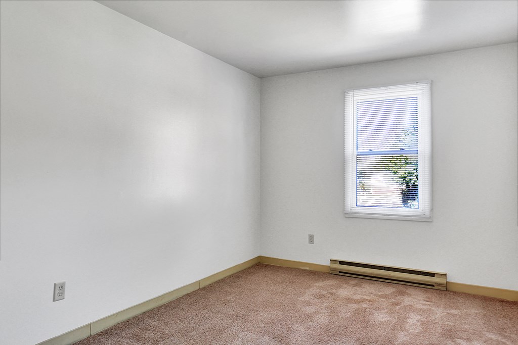 an empty room with white walls and a window