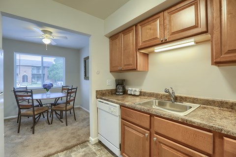 a kitchen with a sink and a table with chairs