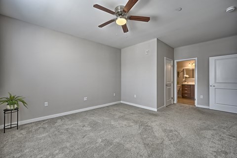 a living room with carpet and a ceiling fan