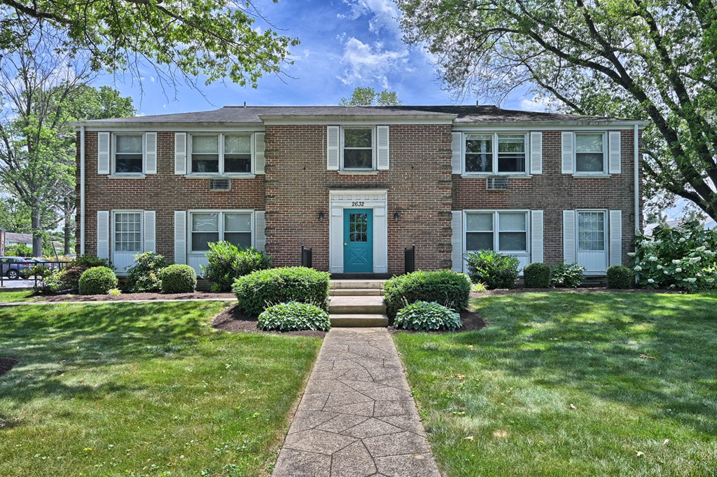 the front of a brick house with a blue front door