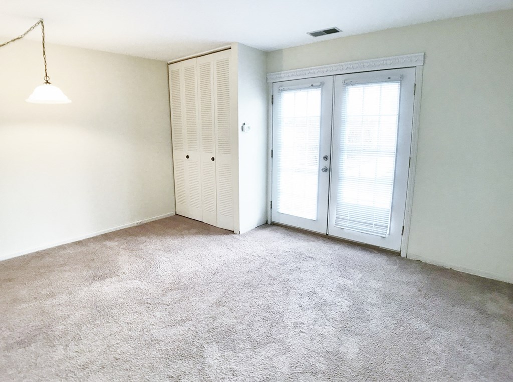 an empty living room with white walls and white doors