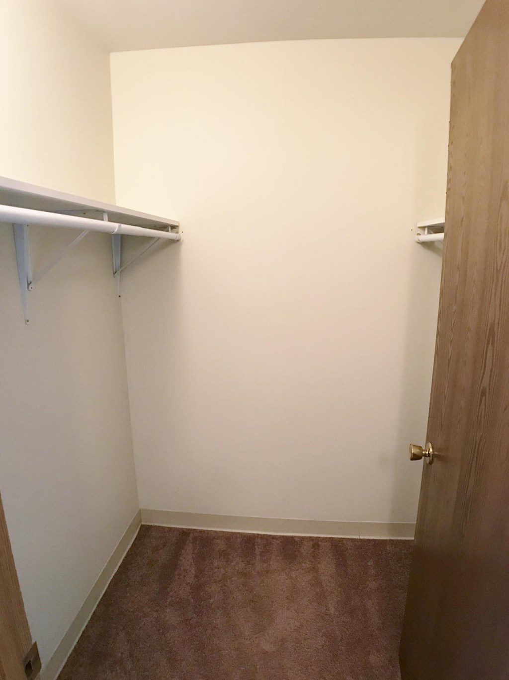 a walk in closet in a room with a door to a closet