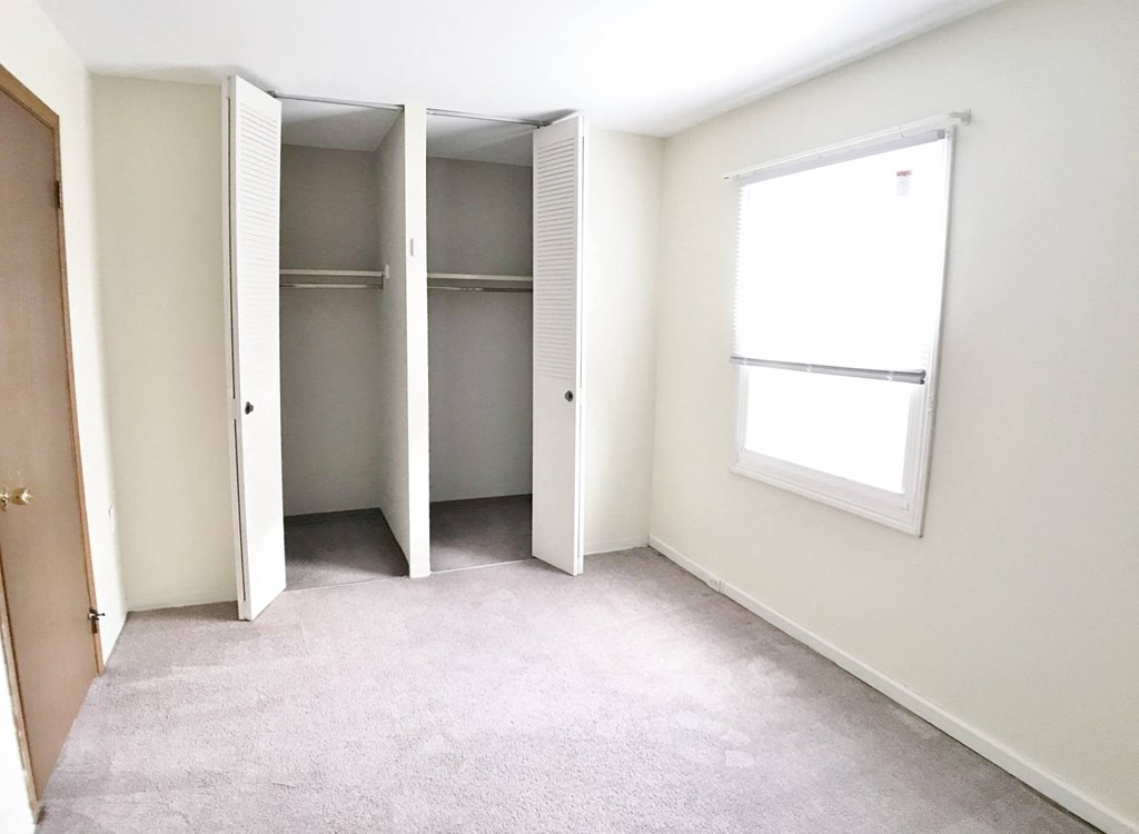 an empty room with two closets and a window