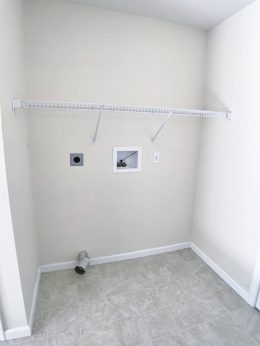 a room with a closet and a white wall with two pictures on it