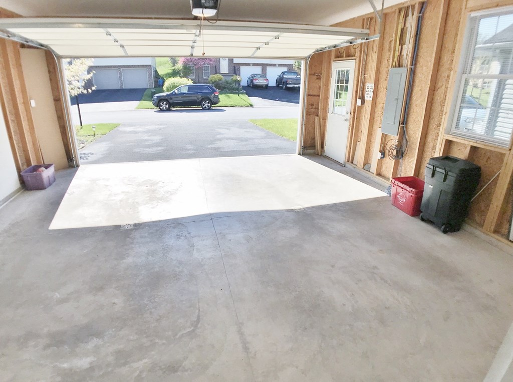a garage with white concrete on the floor and a car in the back