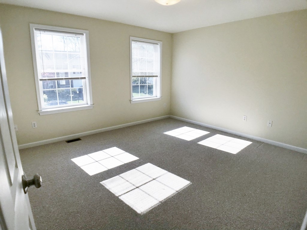 an empty room with sunlight coming through the windows