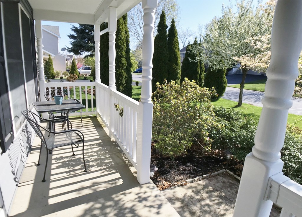 a patio with a table and chairs on a porch