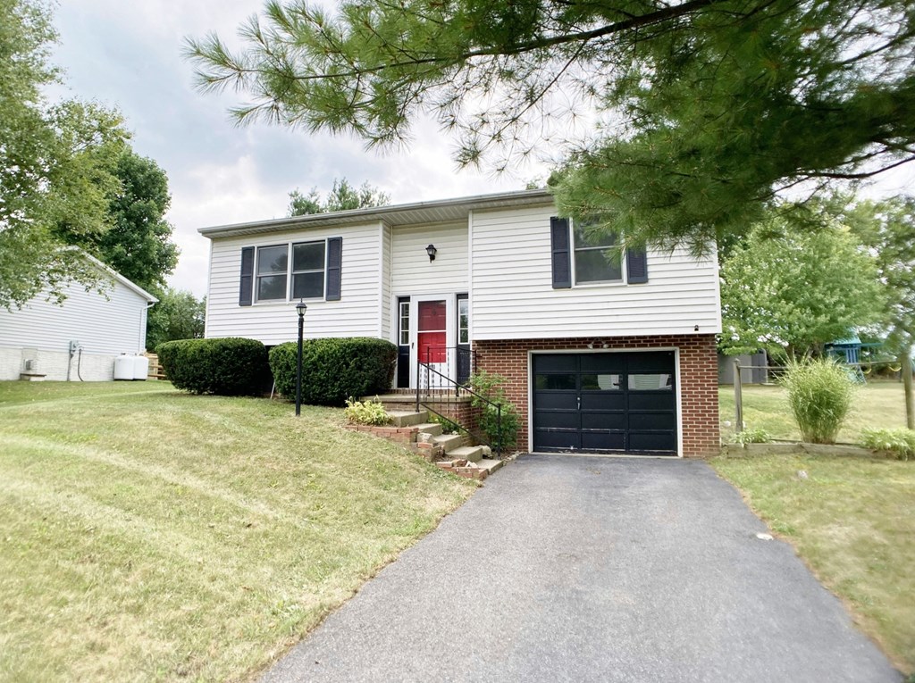 a white house with a driveway and a black garage door