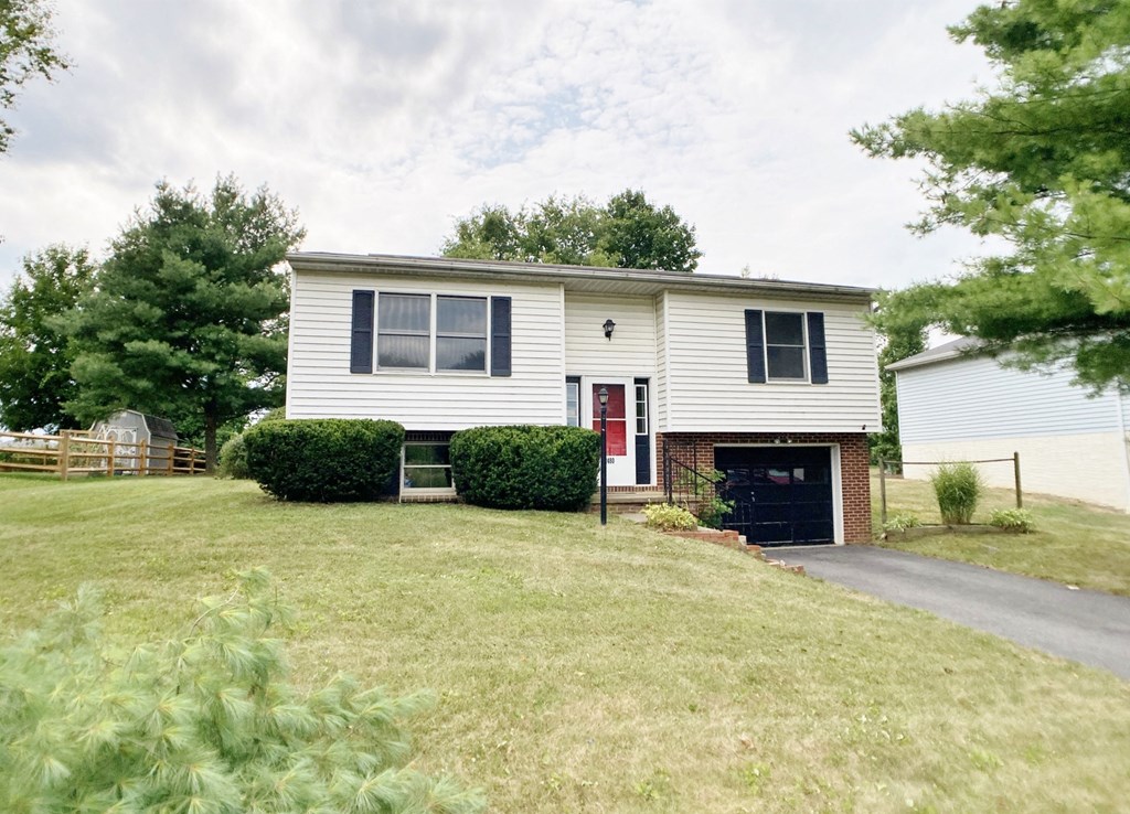 a white house with a red door and a driveway