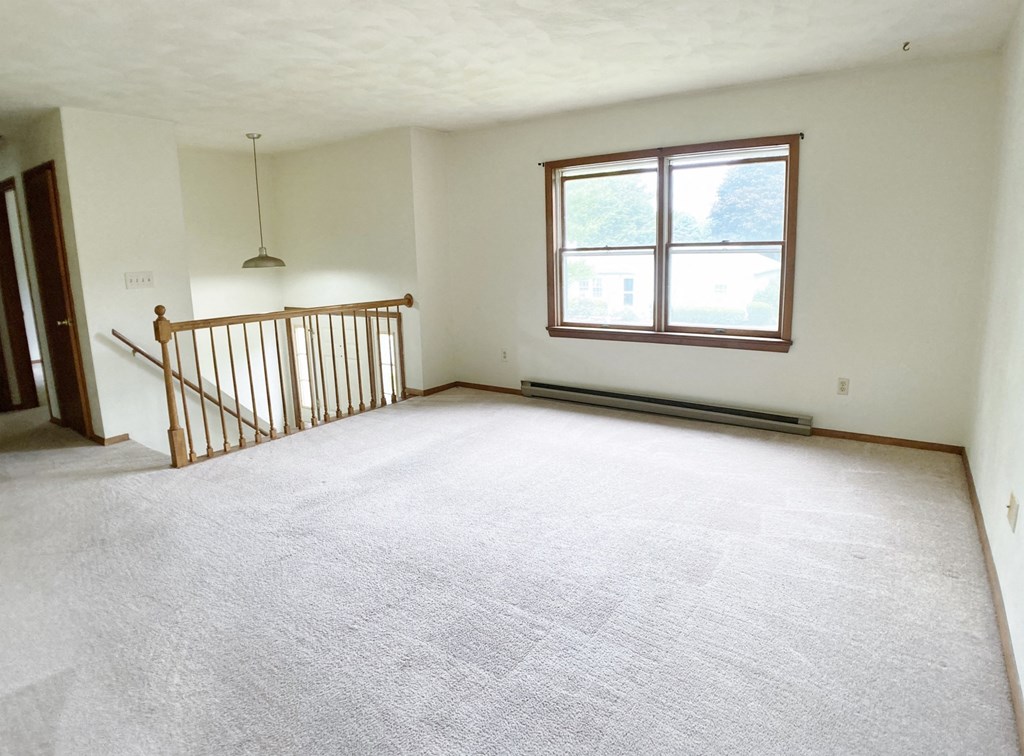 the living room of an empty house with a large window