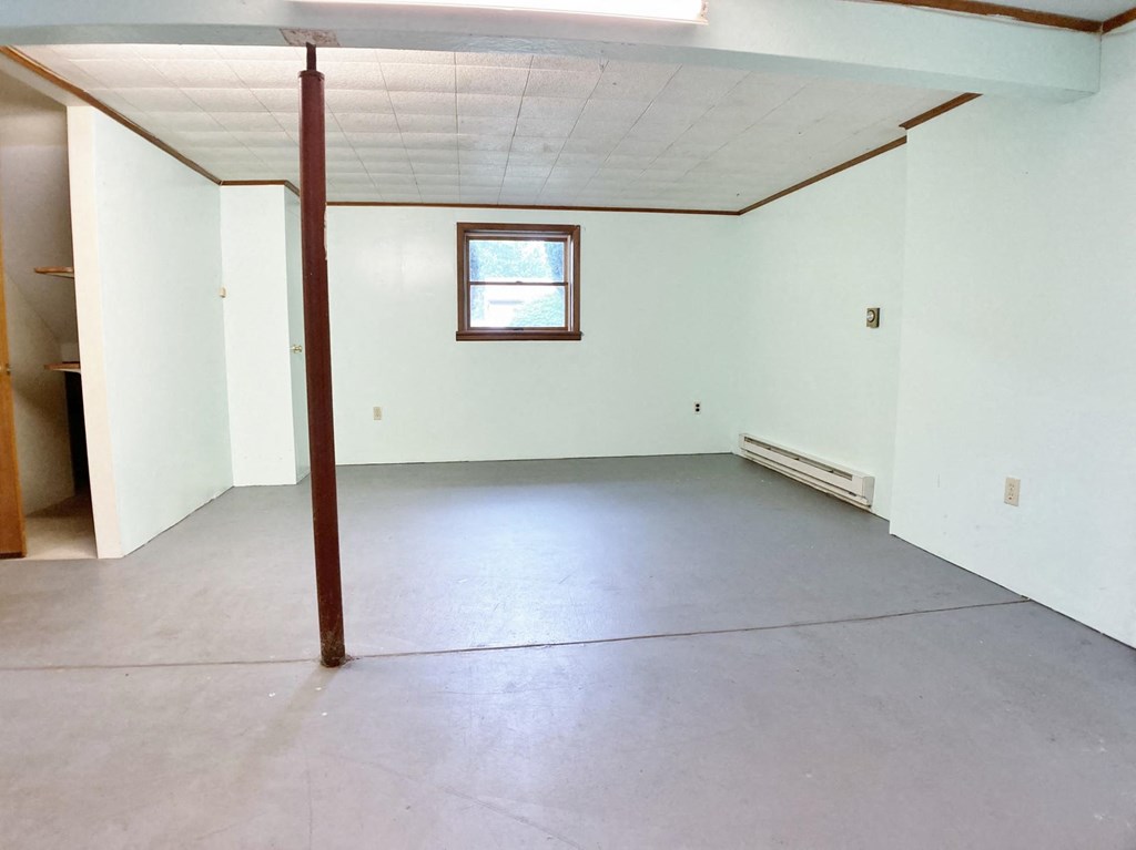an empty room with white walls and a window