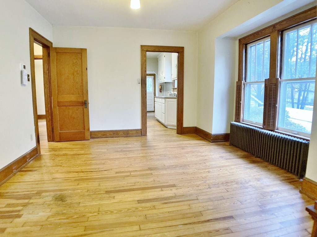 an empty living room with wood floors and windows