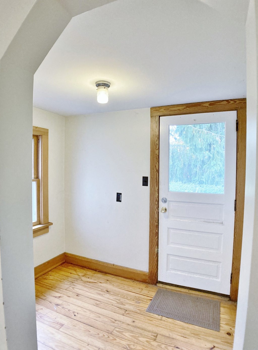 an empty room with a white door and a window