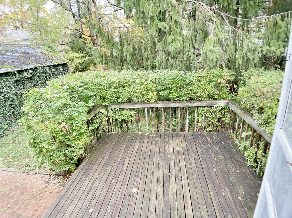 a backyard deck with a wooden railing and trees