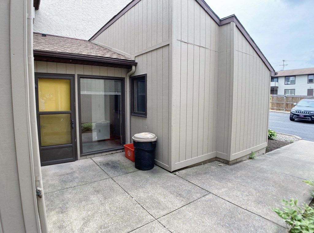 a small building with a trash can in front of it