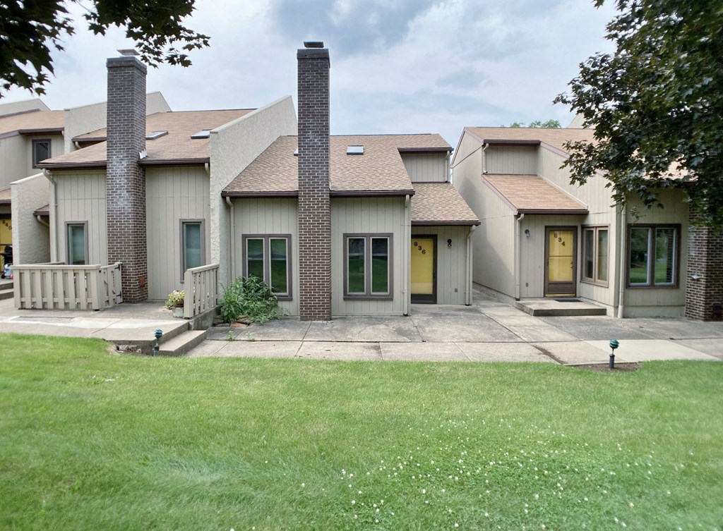 a group of houses with yellow doors and a lawn