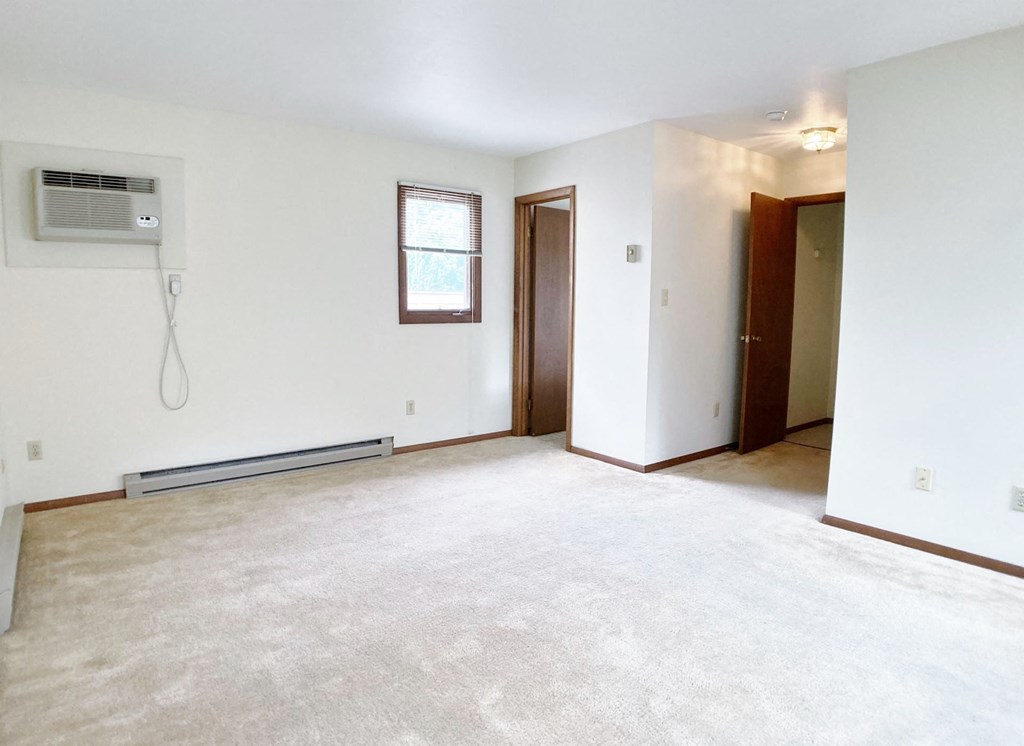 an empty living room with white walls and a white carpet